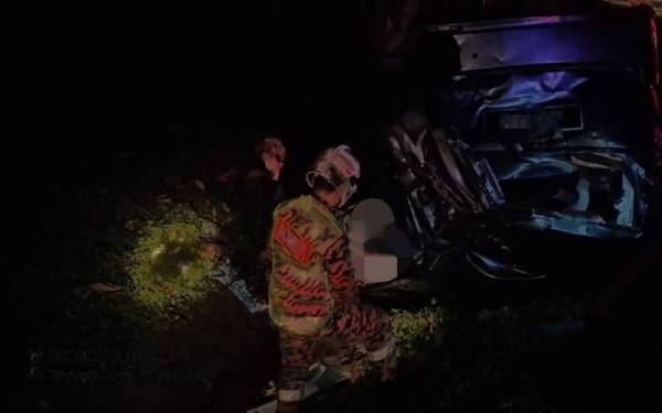 Anggota bomba membantu mengeluarkan mangsa daripada kenderaan yang terbabas.