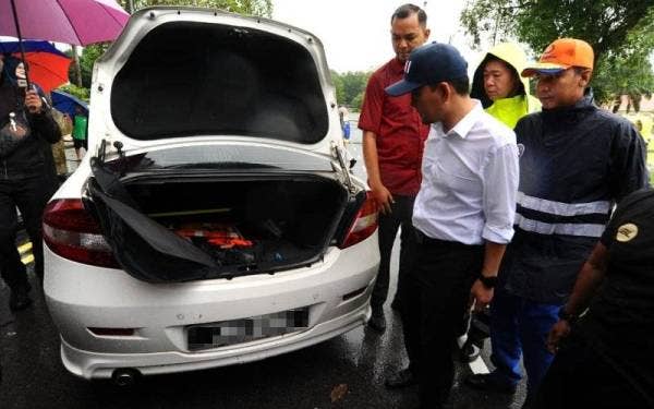 Onn Hafiz melihat sebuah kereta yang dimasuki air selepas melakukan tinjauan mengejut di kawasan banjir kilat di Jalan Ayer Molek pada Selasa.