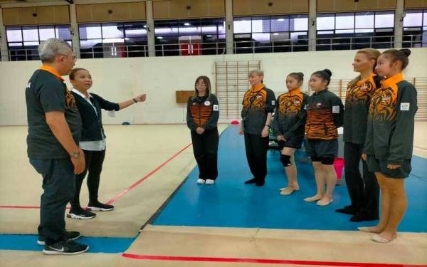 Ketua Kontinjen Malaysia, Datuk Shahrul Zaman Yahya mendengar taklimat daripada Afrita ketika mengadakan lawatan bagi meninjau persiapan skuad gimnastik negara di Gimnasium 1 Majlis Sukan Negara, Bukit Jalil bulan lalu.