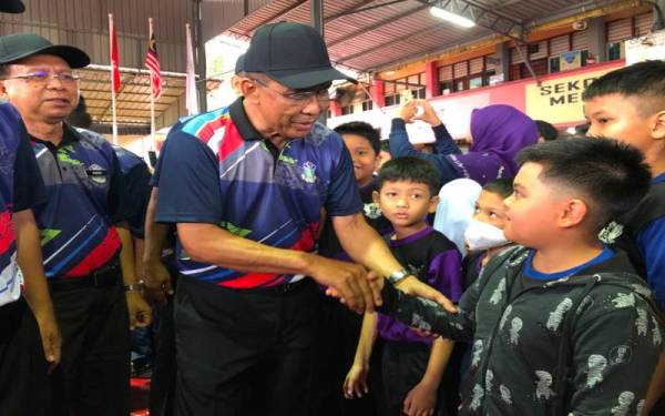 Takiyuddin (dua kiri) beramah mesra dengan murid SK Islah, Kota Bharu pada Rabu.