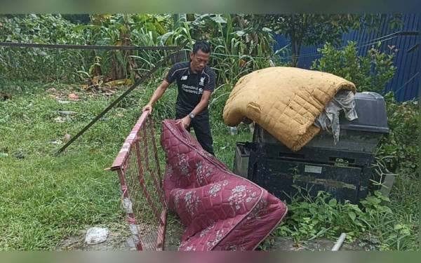 Mohd Shahrir menunjukkan tilam yang rosak akibat banjir pada Selasa.