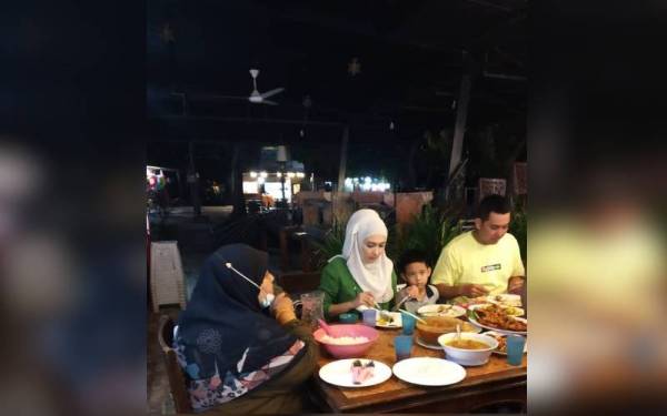 Wan Aishah (tengah) dan suaminya, Alee Tongyon (kanan) menjamu selera di Restoran Bamboo Chenang ketika bercuti di Pulau Langkawi. - Foto Ihsan Mior Johan Johari