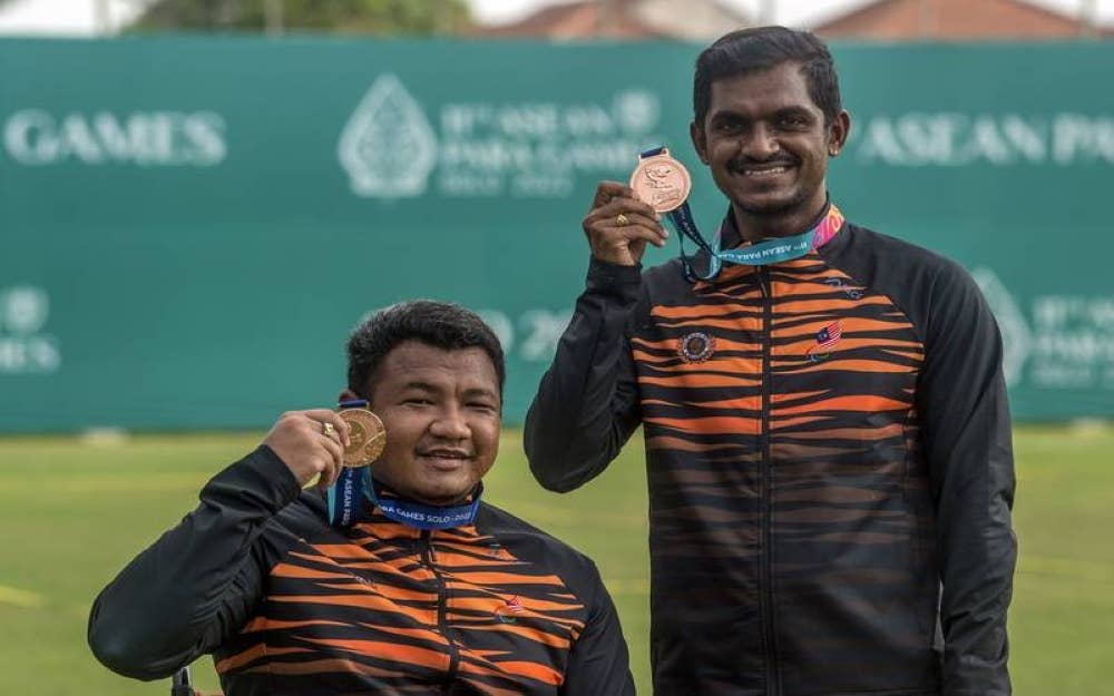 Suresh (kanan) dan Nurfaizal menunjukkan pingat gangsa yang diraih dalam acara memanah recurved berkumpulan lelaki pada temasya APG 2022 Solo di Stadium Kota Barat pada Rabu. - Foto Bernama