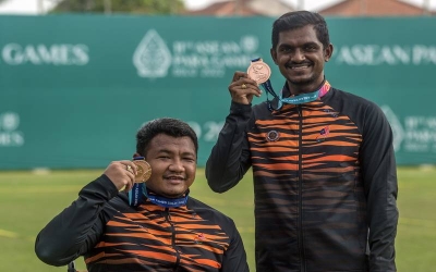 Suresh (kanan) dan Nurfaizal menunjukkan pingat gangsa yang diraih dalam acara memanah recurved berkumpulan lelaki pada temasya APG 2022 Solo di Stadium Kota Barat pada Rabu. - Foto Bernama