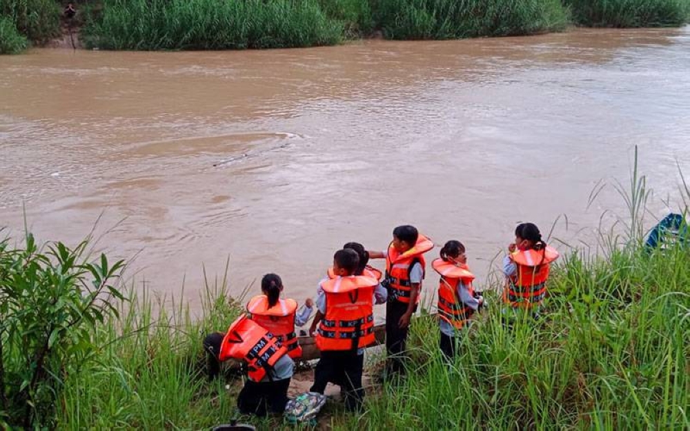 Sebahagian murid dibawa Maratin untuk menyeberang sungai menggunakan sampan hanya mampu memuatkan beberapa murid saja dalam satu-satu masa.