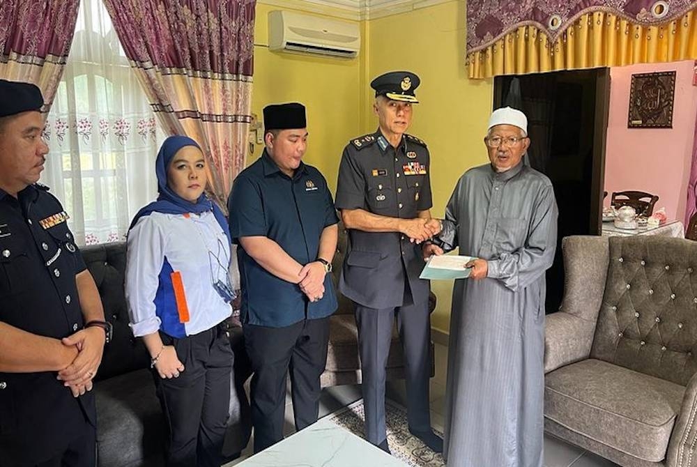 Sumbangan disampaikan Mohamed Zahari kepada pengetua sekolah, Abdul Rahman pada Khamis. - Foto Facebook Istana Negara