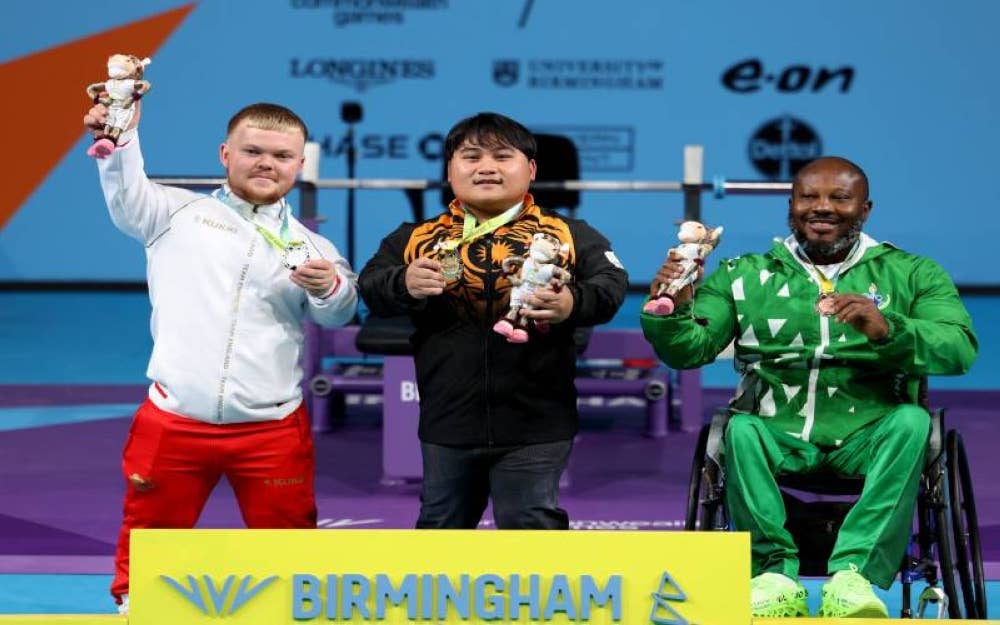 Atlet powerlifting negara Bonnie Bunyau Gustin bergambar bersama pemenang pingat Perak dari England, Mark Swan (kiri) dan pemenang pingat Gangsa dari Nigeria, Innocent Nnamdi bagi acara Angkat Berat Kategori Lelaki Lightweight semasa Sukan Komanwel Birmingham 2022 di National Exhibition Centre pada Khamis. - Foto Bernama

