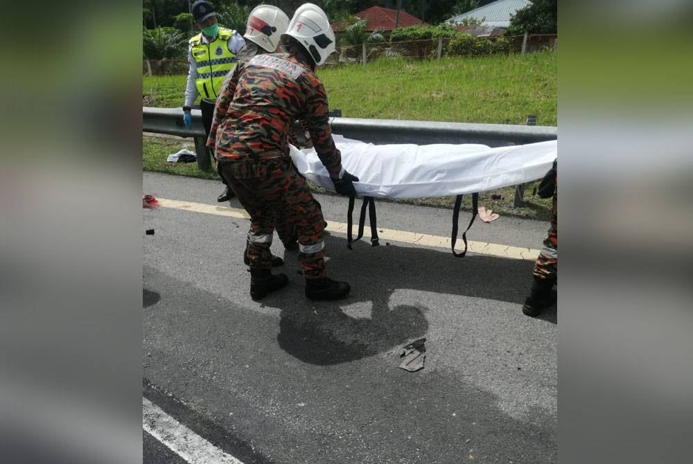 Anggota bomba bertugas mengangkat mayat mangsa untuk diserahkan kepada pihak polis. - Foto ihsan Bomba Perak
