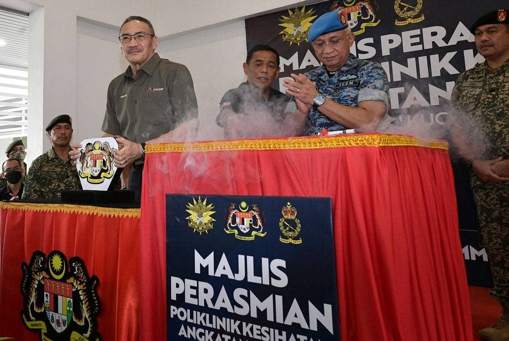 Menteri Kanan Pertahanan Datuk Seri Hishammuddin Tun Hussein meletakkan replika kunci pada gimik perasmian Poliklinik Kesihatan Angkatan Tentera Malaysia (ATM) Kem Penrissen. - Foto Bernama