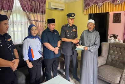 Sumbangan disampaikan Mohamed Zahari kepada pengetua sekolah, Abdul Rahman pada Khamis. - Foto Facebook Istana Negara