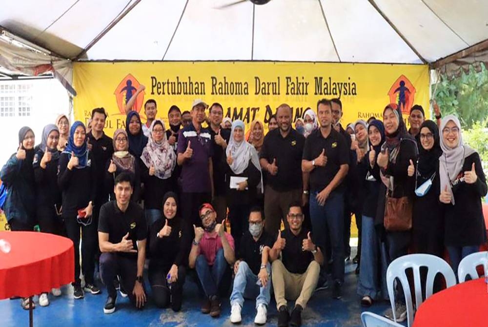 Ramli (enam dari kanan) bersama sukarelawan yang menyertai gotong-royong di Pertubuhan Rahoma Darul Fakir Malaysia, Subang Jaya pada Sabtu.