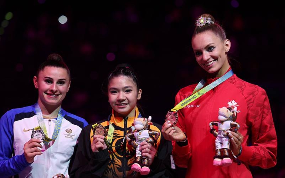 Joe Ee (tengah) bergambar bersama pemenang pingat perak dari Scotland, Christie Louise(kiri) dan Pingat gangsa dari Canada, Carmel Kallema pada penyampaian pingat acara 'Ribbon' gimnastik berirama sempena Sukan Komanwel 2022 Birmingham di Arena Birmingham pada Sabtu. - Foto Bernama