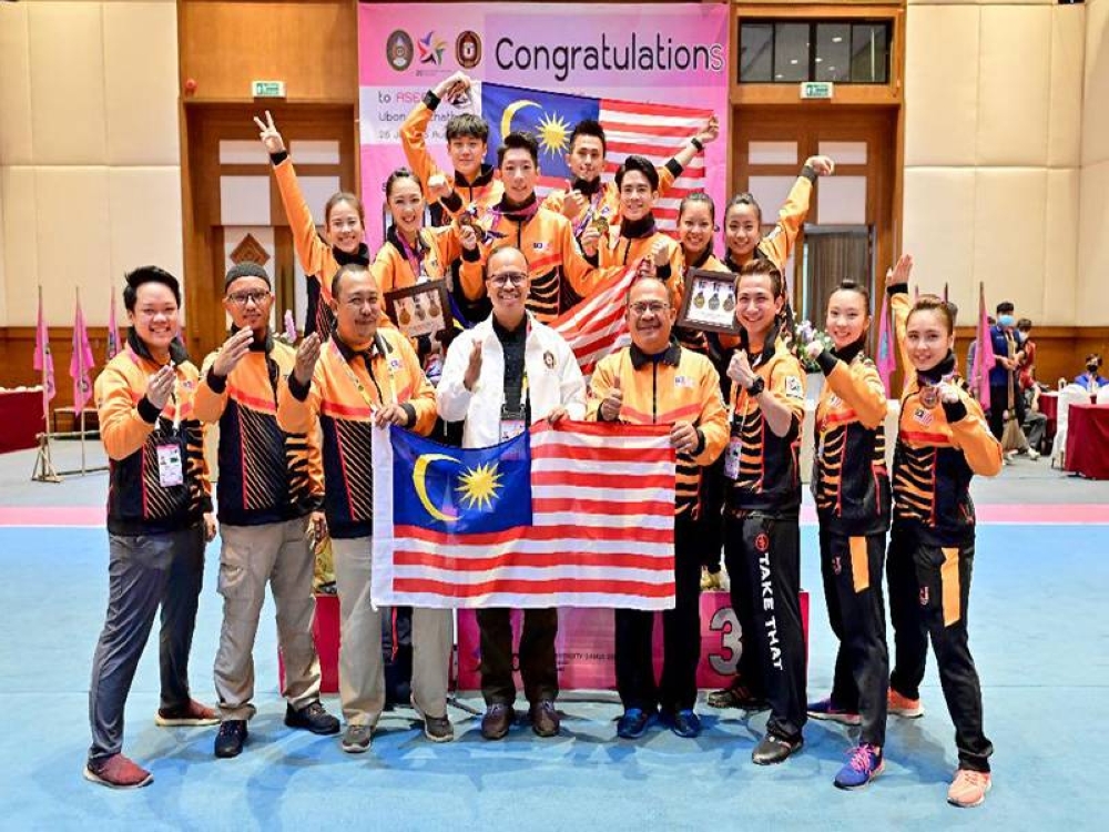 Mohd Foa'ad (empat dari kanan) bergambar bersama skuad wushu di temasya AUG 2022.