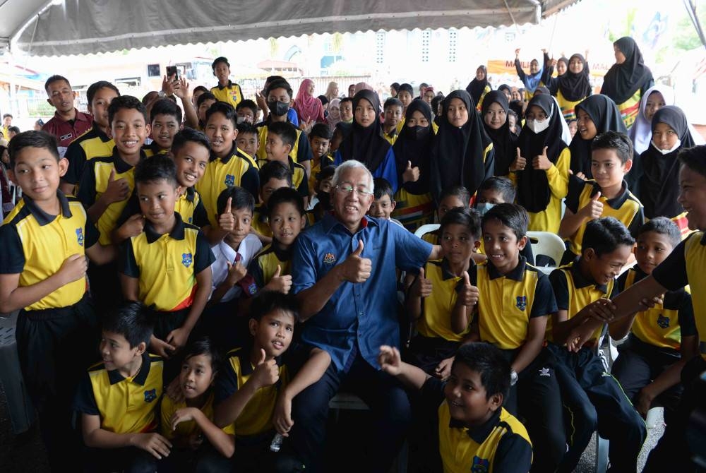 Menteri Pembangunan Luar Bandar Datuk Seri Mahdzir Khalid (kanan) menyantuni kanak-kanak Felda pada Program Semarak Desa Komuniti di Felda Bukit Tembaga, Kuala Nerang, pada Ahad. - Foto Bernama
