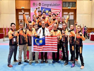 Mohd Foa'ad (empat dari kanan) bergambar bersama skuad wushu di temasya AUG 2022.