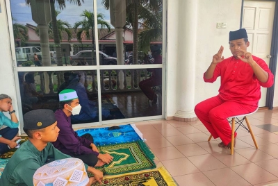 Ahmad Mustaqim (depan) membantu jemaah OKU pendengaran menerusi penggunaan bahasa isyarat ketika khutbah Jumaat di Masjid Temerloh Jaya.