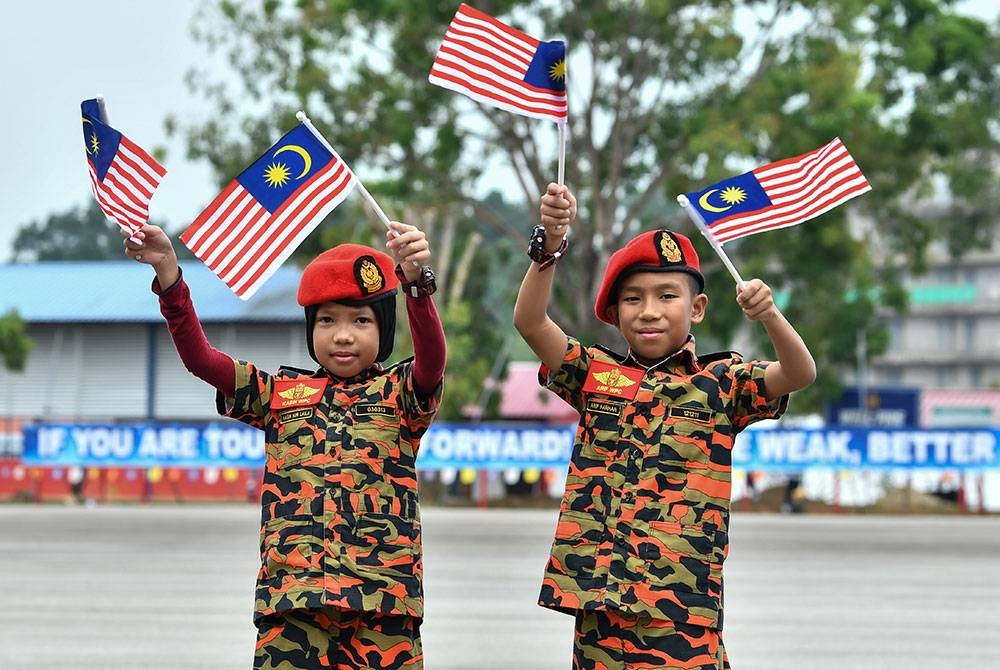 Gelagat ‘bomba’ cilik Muhammad Arif Farhan Mohamad Firdaus, 11, (kanan) dan adiknya Kasih Nur Laila, 9, mengibarkan Jalur Gemilang sempena Bulan Kebangsaan pada Majlis Perbarisan Pentauliahan Sijil Sains Kebombaan Siri 1, 2022 di Akademi Bomba dan Penyelamat Malaysia Wilayah Timur, Wakaf Tapai hari ini.
