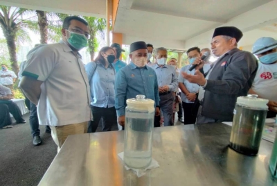 Tuan Ibrahim (tengah) diberi taklimat mengenai proses penghasilan etanol dan biogas daripada pemprosesan air kumbahan.