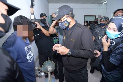 Khairul Dzaimee memeriksa seorang warga asing semasa Op Kutip di kawasan rumah kedai di Kompleks Hentian Kajang, Selangor pada Selasa.