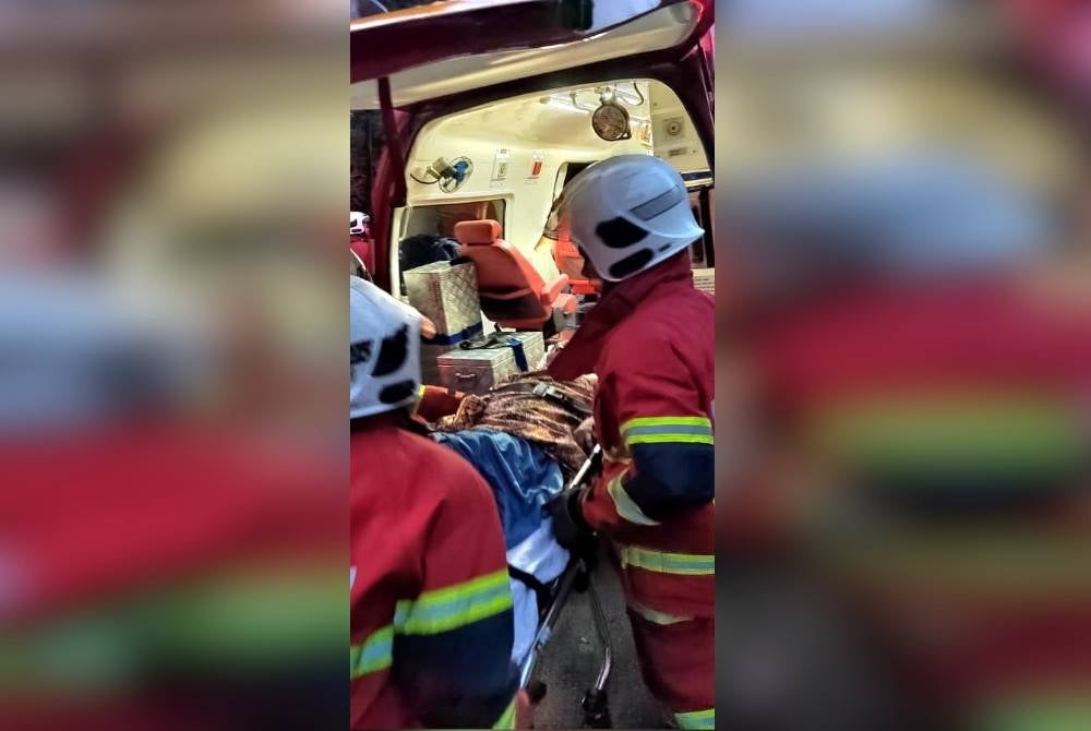 Anggota bomba membantu seorang warga emas yang melecur dalam kebakaran di di Jalan Kesang Laut, Kampung Kesang Laut, Tangkak, pada Selasa.