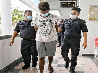 Suren (dua, kiri) ketika dibawa keluar dari Mahkamah Sesyen di sini, pada Rabu.