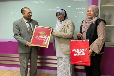 Norhayati (tengah) dan Wan Normi menyampaikan cenderahati kepada Fazli Rizal.