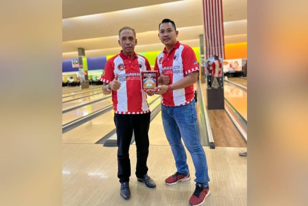 Rozaki (kanan) menyampaikan cenderahati kepada Wan Hassan.