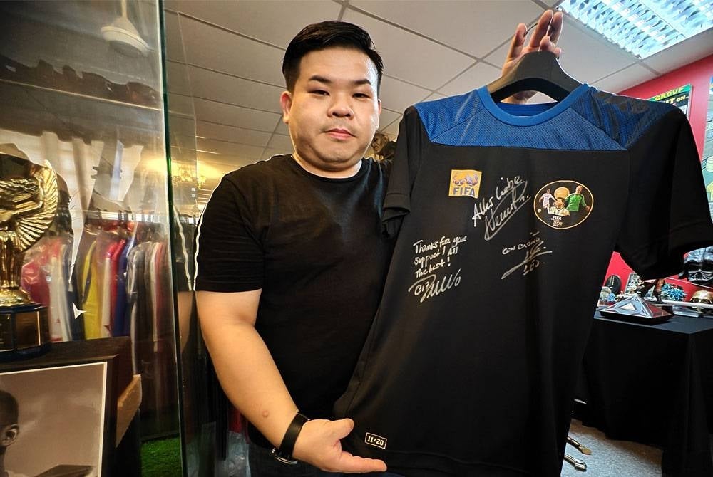 Jin Zhen menunjukkan jersi Ballon d'Or yang merupakan edisi terhad ditandatangani oleh Manuel Neuer, Christiano Ronaldo dan Lionel Messi.