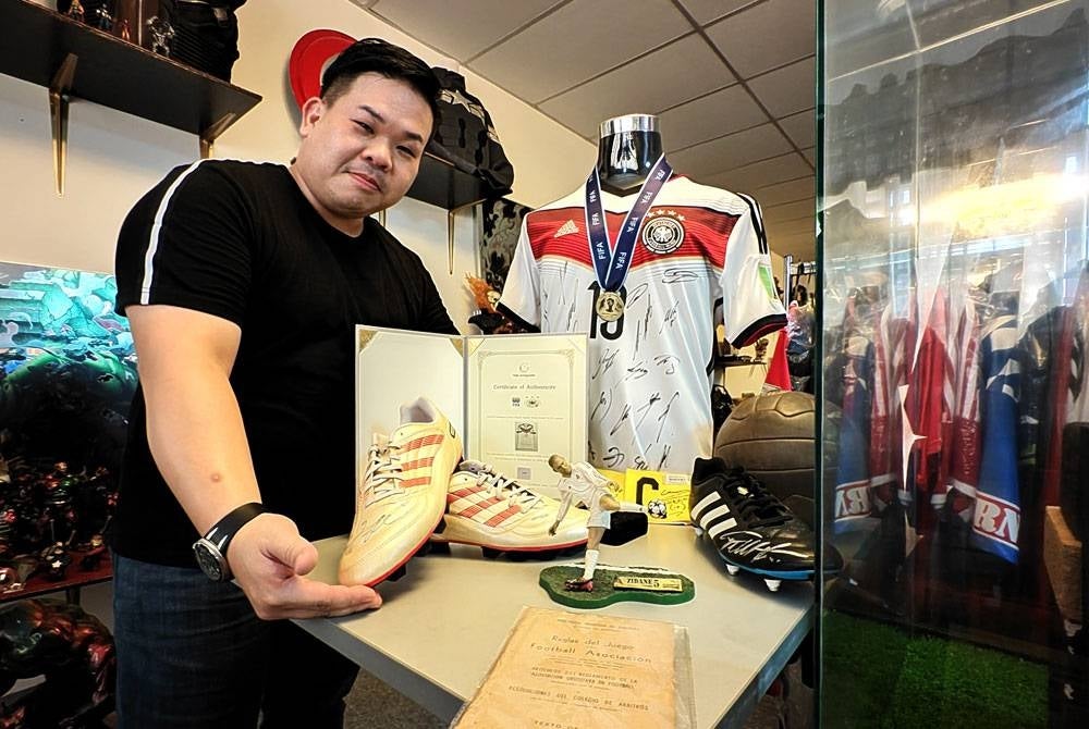 Jin Zhen menunjukkan antara koleksi Piala Dunia.