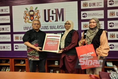 Dr Shaharum (kiri) menerima cenderahati daripada Nurhayati dan Wan Normi.