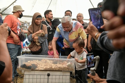 Ismail Sabri menyantuni pengunjung cilik yang hadir ketika sesi lawatan sempena MAHA 2022 di Taman Ekspo Pertanian Malaysia (MAEPS) hari ini. Foto Bernama