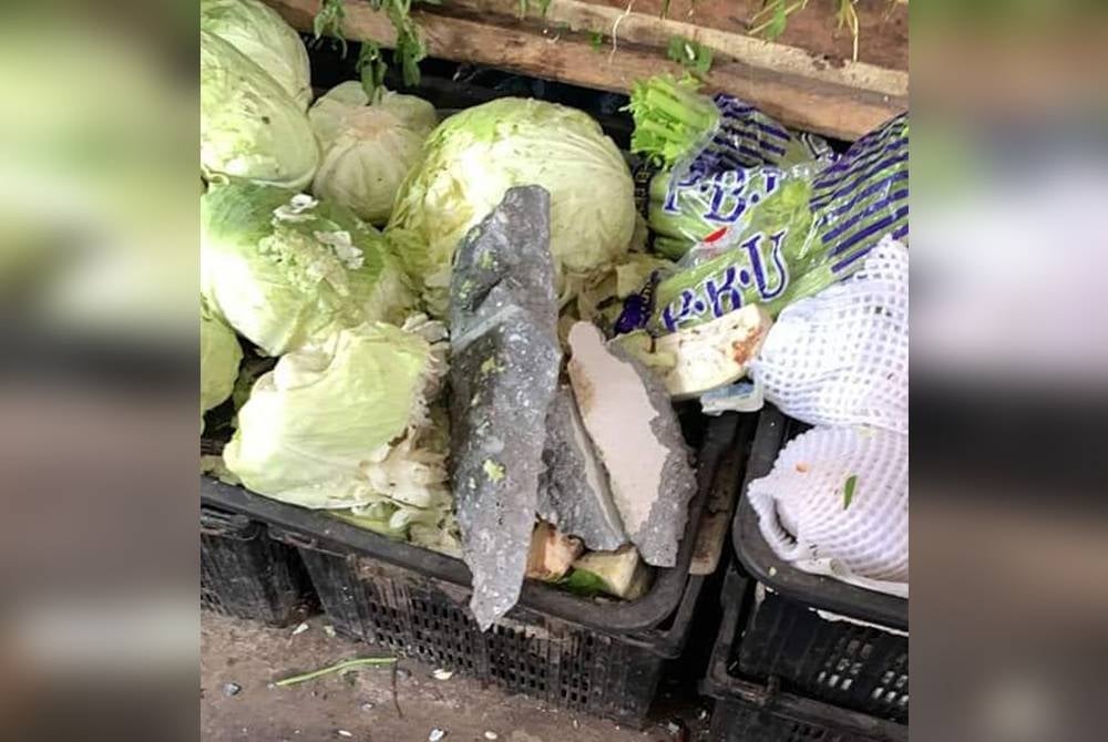 Kepingan simen jatuh ke atas sayur yang dijual oleh peniaga di Kompleks Pasar Meru Klang, di sini.