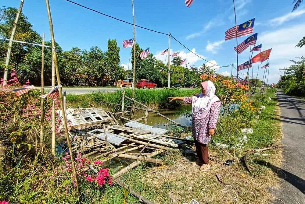 Norhayawati menunjukkan titi usang yang akan dibaik pulih oleh suaminya untuk mendapatkan suasana yang lebih meriah.