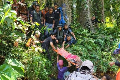 Pasukan mencari dan menyelamat membawa Painah yang ditemukan dalam keadaan lemah berhampiran lopak air dalam kawasan kebun kelapa sawit di Kampung Parit Kasih Sayang Senggarang, Batu Pahat pada Isnin.