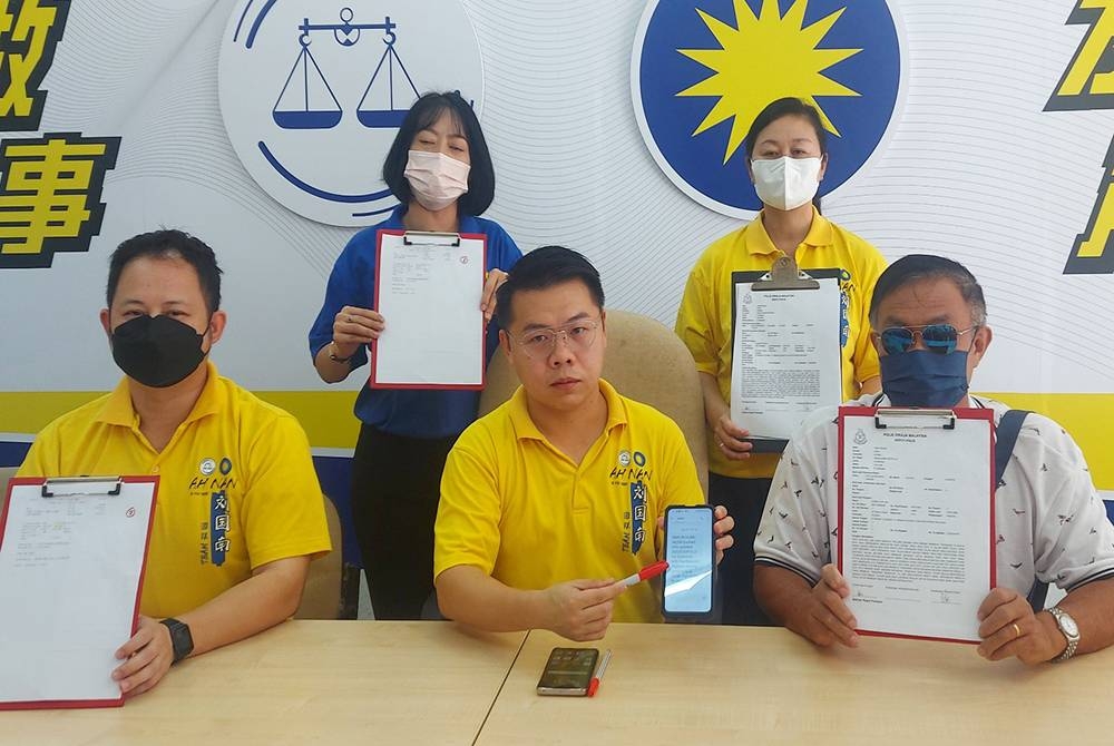 Yeo Wai (kanan) menunjukkan laporan polis yang dibuat berhubung kehilangan wangnya dipercayai digodam bulan lalu.