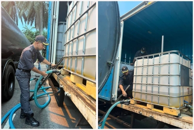 Penguat kuasa KPDNHEP menunjukkan proses pemindahan minyak diesel bersubsidi yang dilakukan dua lelaki terbabit.