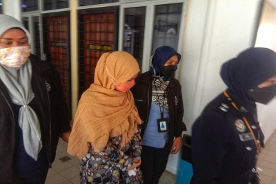 Tertuduh (tengah) ketika dibawa keluar dari kamar mahkamah, pada Rabu.