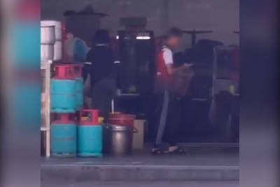 Tangkap layar video memaparkan dua pekerja kedai nasi ayam yang didakwa mengambil bahan masakan daripada restoran bukan Islam di Paya Terubong.