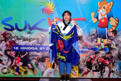 Humairah meraikan kejayaannya meraih dua emas buat UM di gelanggang taekwondo.