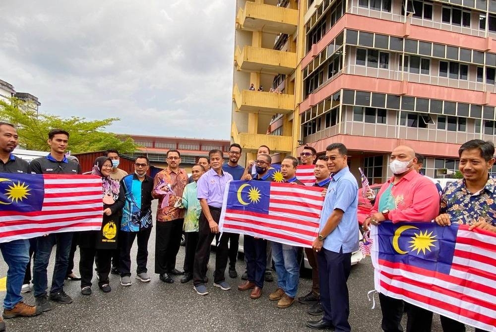 Muhd Nor Aswadi (tiga dari kanan) bersama Dr Zaini (tujuh dari kiri) semasa Majlis Pelancaran Kempen Kibar Jalur Gemilang di Peringkat Wisma Persekutuan di Kota Bharu pada Khamis.