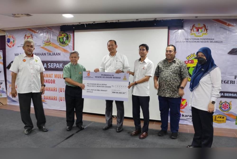 Ketua Pegawai Eksekutif PNSB, Raja Ahmad Shahrir Iskandar Raja Salim (tiga dari kanan) menyampaikan replika cek penajaan Piala Datuk Mokhtar Dahari (bawah 15 tahun) kepada Emran (dua dari kiri) sambil disaksikan Mohd Khairuddin (tiga dari kiri) di Kompleks Kumpulan Karangkraf, Shah Alam pada Khamis