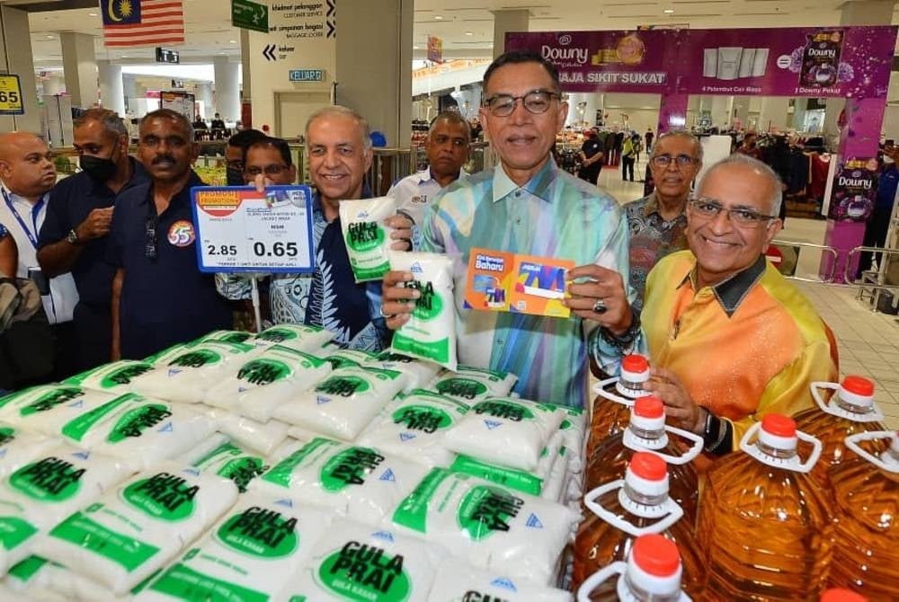 Rosol (dua dari kanan) dan Ameer (tiga dari kanan) menunjukkan harga gula yang dijual di Mydin.