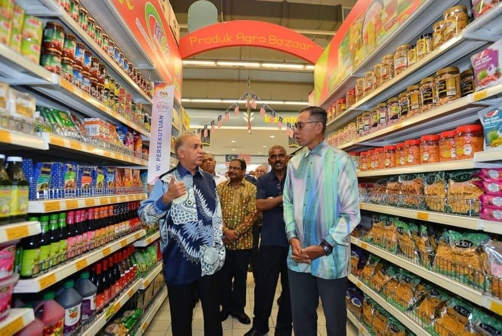 Ameer (kiri) menerangkan sesuatu kepada Rosol (kanan) ketika membuat lawatan di pasar raya Mydin Seremban 2 pada Khamis. -FOTO SINARHARIAN/HALIM WAHID