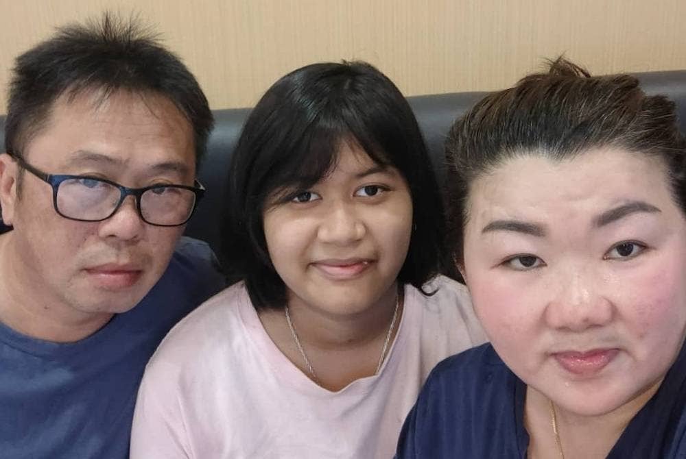 Tee Hui Nee (tengah) bersama ibu bapa angkatnya berharap dapat bertemu semula dengan ibu bapa kandungnya.