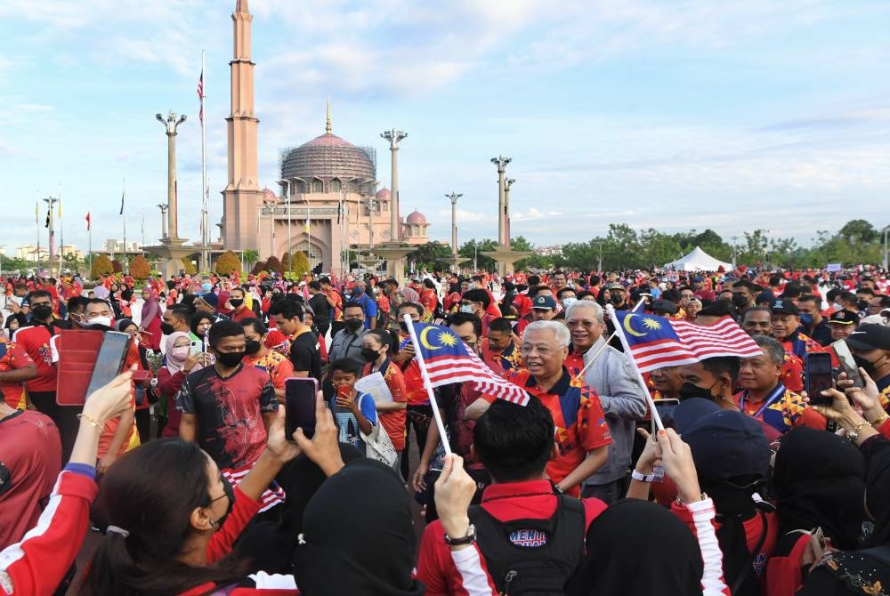 Ismail Sabri berjalan sambil mengibarkan Jalur Gemilang pada Program 'Berjalan Teguh Bersama' sempena majlis Pelancaran Bulan Kebangsaan dan Kibar Jalur Gemilang 2022 di Dataran Putra pada 30 Julai lalu. - Foto Bernama