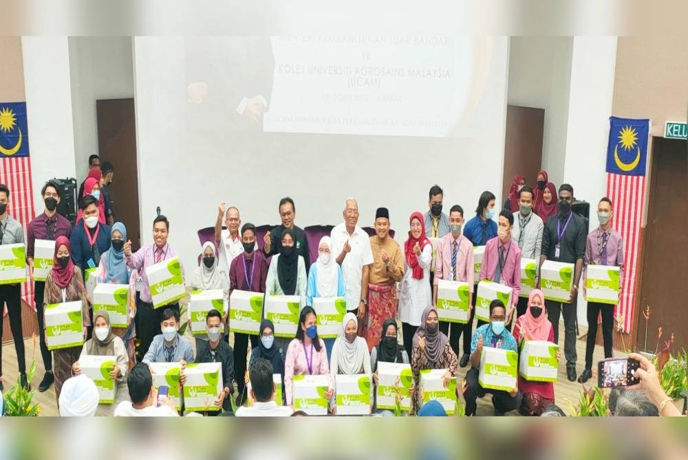 Menteri Pembangunan Luar Bandar, Datuk Seri Mahdzir Khalid (tengah) bergambar bersama sebahagian pelajar yang juga penerima bakul makanan sempena program lawatan ke UCAM di Ayer Paabas, pada Jumaat.