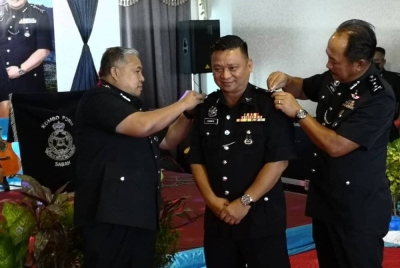 Idris (kiri) dan Jauteh (kanan) menyempurnakan pemakaian pangkat kepada Champin pada Majlis Pemakaian Pangkat Pegawai Kanan di Ibu Pejabat Kontinjen (IPK) Sabah, Kota Kinabalu.