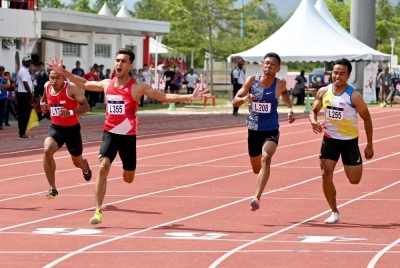 Muhammad Fakhrul (dua dari kiri) meraikan kejayaan mengungguli acara 100 m lelaki.