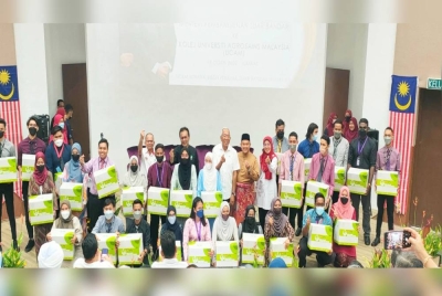 Menteri Pembangunan Luar Bandar, Datuk Seri Mahdzir Khalid (tengah) bergambar bersama sebahagian pelajar yang juga penerima bakul makanan sempena program lawatan ke UCAM di Ayer Paabas, pada Jumaat.