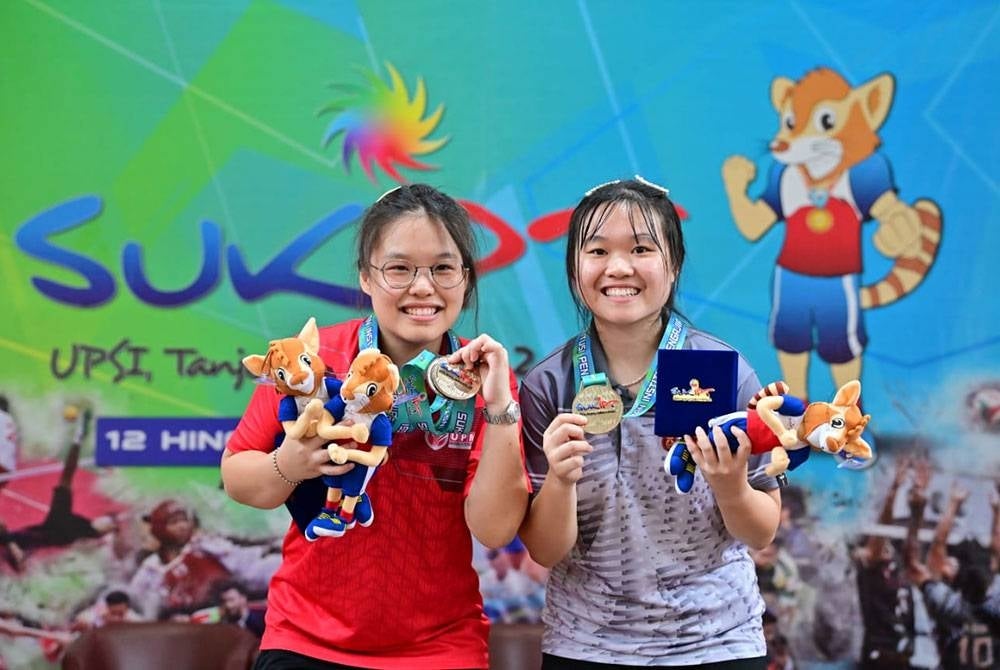 Crystal (kanan) bersama adiknya Esther bergambar bersama pingat yang dimenangi mereka dalam acara perseorangan wanita ping pong SUKIPT 2022.